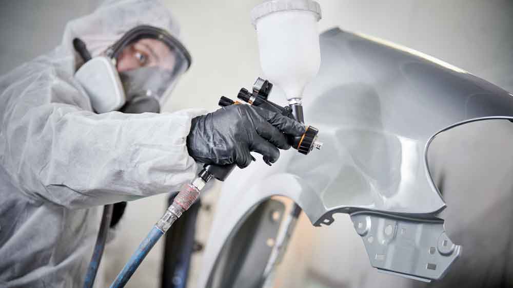 Collision Repair Services - Painter in booth spraying fender